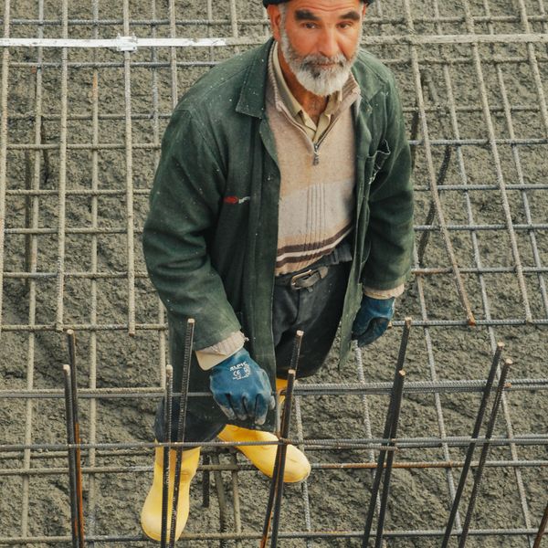 道具を手に微笑むベテラン職人サンプル山本さん